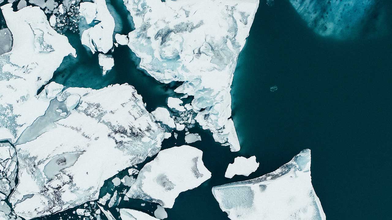 Platforms of white sea ice move on a blue ocean surface